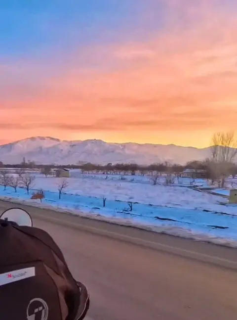 Route enneigée en Turquie au coucher du soleil, vue depuis la moto
